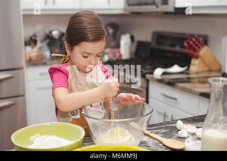 Glückliche Familie in der Küche, die Mutter und Tochter kochen Apfelkuchen, Mixen von Teig Stockfoto