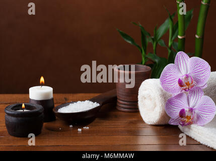 Spa Einstellung mit Meersalz, Kerzen, Handtücher, Steine und Orchideen. Stockfoto