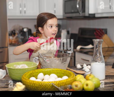 Glückliche Familie in der Küche, die Mutter und Tochter kochen Apfelkuchen, Mixen von Teig Stockfoto