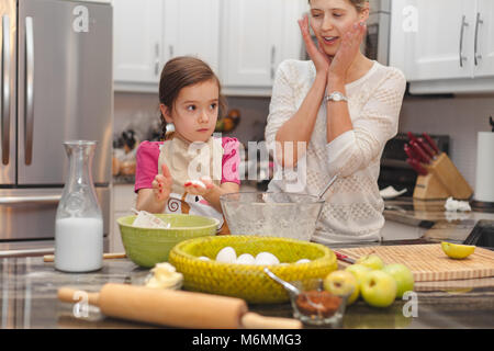 Glückliche Familie in der Küche, die Mutter und Tochter kochen Apfelkuchen, Mixen von Teig Stockfoto