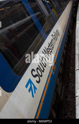 Asouthwestern Bahn Logo oder Marke Abzeichen auf der Seite einer Bahn Reisebus in der Plattform in London Waterloo statuion. Zug tätigen Unternehmen. Stockfoto