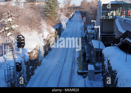 Passagiere erwarten die Ankunft der O-Bahn an einem winterlichen Carling Station, Ottawa, Ontario, Kanada. Stockfoto