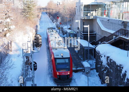 OC Transpo O-Bahn zieht an einem verschneiten Carling Station an einem Wintertag, Ottawa, Ontario, Kanada. Stockfoto