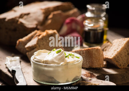 Scheiben Brot mit Frischkäse und Kräutern an Bord Stockfoto