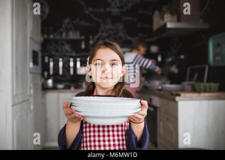 Ein kleines Mädchen mit Großmutter helfen in der Küche. Stockfoto