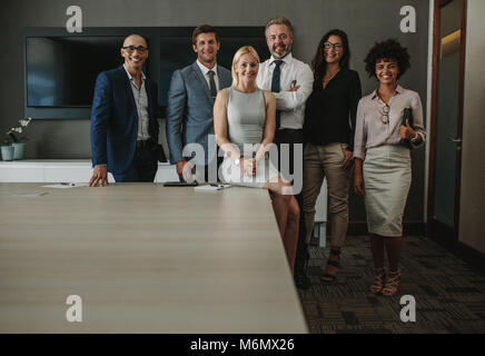 Portrait von freundlich gemischtrassiges Team von Profis zusammen im Sitzungssaal. Team von corporate business professionals an Kamera und Stockfoto