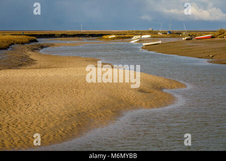 Die blakeney Hafen Mündung mit Sandbänken und Angelegte Boote, North Norfolk, Großbritannien. Bewölkten Himmel. Stockfoto