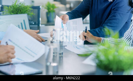 Screenshot des Business Meeting Zimmer Tisch mit Leuten, die gemeinsame Nutzung von Dokumenten mit Kreisdiagrammen und Statistiken, Tablet-PCS und Laptops. Stockfoto