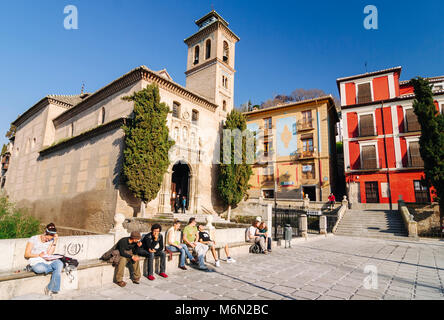 Granada, Andalusien, Spanien. Touristen und Einheimische gleichermaßen Sitzen durch die Santa Ana Kirche an der Plaza Nueva qm in der Unesco Viertel Albaicin. Stockfoto