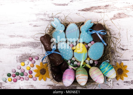 Ostern Lebkuchen Cookies auf Holztisch. Schöne verglaste Hasen und Eier. Grußkarte. Blick von oben. Kopieren. Stockfoto