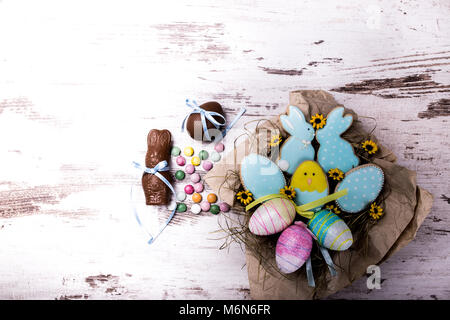 Ostern Lebkuchen cookies und bunten Bonbons auf hölzernen Tisch. Hasen und Eier. Grußkarte. Blick von oben. Kopieren. Stockfoto