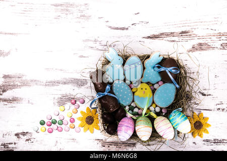 Ostern Lebkuchen cookies und bunten Bonbons auf hölzernen Tisch. Hasen und Eier. Grußkarte. Blick von oben. Kopieren. Stockfoto