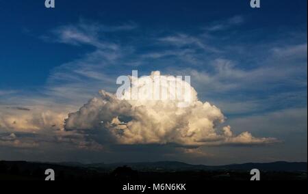 Storm Cloud über die Landschaft. Cloud von der Sonne beleuchtet. Blauer Himmel über. Stockfoto