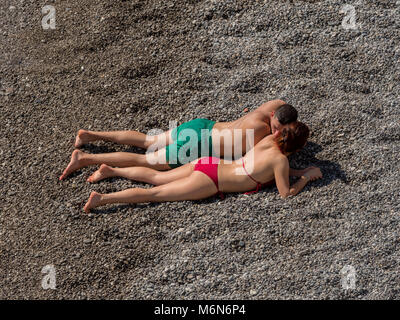 Junges Paar, Sonnenbaden am Strand Stockfoto