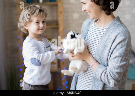 Adorable blonde Junge spielt mit Bunny Stockfoto