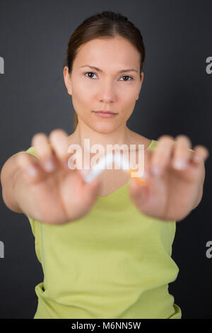 junge Frau bricht eine Zigarette Stockfoto