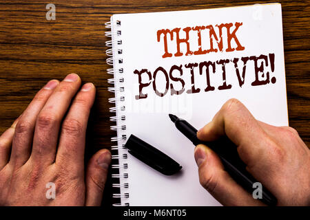 Handschriftlichen Text, Wort Denke positiv. Business Konzept für Positivität Haltung geschrieben Tablet , Holz- Hintergrund mit Geschäftsmann Hand, Stockfoto