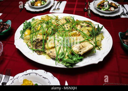 Griechische Zitronen Knoblauch Huhn und Kartoffeln serviert der weißen Platte rot Tischdecke von Schalen der griechischen Salat umgeben und eine Schüssel von Kalamata Oliven Stockfoto