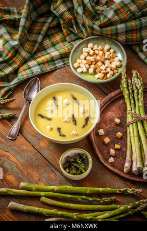 Spargel cremesuppe in einer Schüssel auf einem urigen Hintergrund Stockfoto