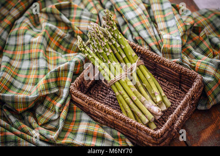 Blumensträuße frischer grüner Spargel im Weidenkorb Stockfoto