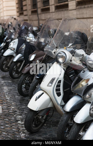 Vespas und andere Motorräder auf gepflasterten Straßen von Rom, Latium, Italien. Stockfoto