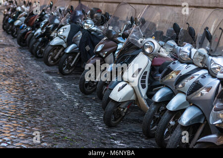 Vespas und andere Motorräder auf gepflasterten Straßen von Rom, Latium, Italien. Stockfoto