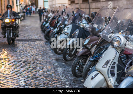 Vespas und andere Motorräder auf gepflasterten Straßen von Rom, Latium, Italien. Stockfoto