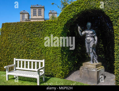 Eine der vier muse Skulpturen in einer Nische durch eine sauber abgeschnitten Eiben Hecke in den Gärten von Hardwick Hall in Derbyshire UK gebildet Stockfoto