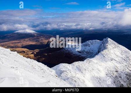 Hohe Aussicht auf Y Lliwedd in Snowdon Horseshoe aus South Ridge im Winter Schnee in Snowdonia National Park. Die schneebedeckten Moel Siabod in Distanz. Wales UK Stockfoto