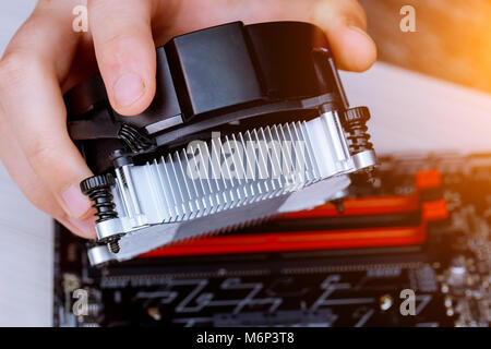 Techniker Hände installieren CPU Kühler Lüfter auf einem Computer pc-motherboard Extraktion von crypto Währung von Grafikkarten Stockfoto