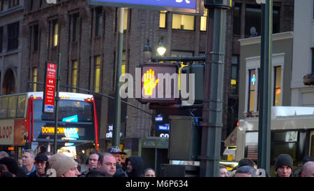 New York City - ca. 2017: Beleuchtete zu Fuß Symbol auf street lamp Pol in Midtown Manhattan während der Rush Hour. Pendler warten für den Autoverkehr zu Stockfoto