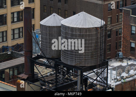 Wasserturm sitzt auf Manhattan Apartment Gebäude in New York City. Trinkwasser an Mieter für Baden, Duschen und Kochen Stockfoto