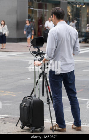 New York City, ca. 2017: Männlich Fotograf stehen auf New York City Straße Ecke Aufzeichnen von Videos mit professionellen Kameraausrüstung Stockfoto