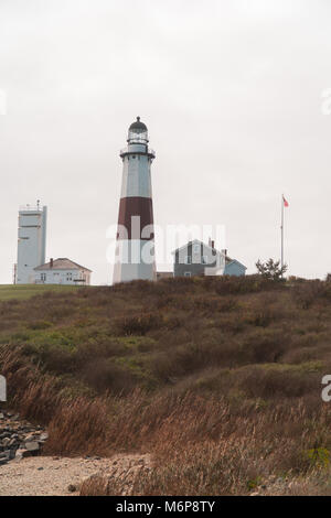 Große schöne Aussicht auf die Küste Meer Leuchtturm hoch oben grün Natur Platz am Ufer. Amerikanische Flagge Wellen im Meer Brise Wind. Rock Stockfoto