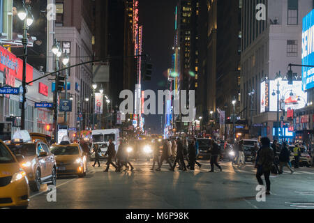 New York City, ca. 2017: Nacht Zeit großem Betrachtungswinkel von Midtown Manhattan NYC crosswalk während der Rush Hour. Menschen gehen sicher über Avenue intersecti Stockfoto