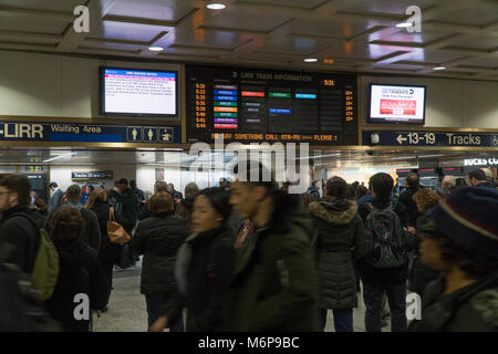 New York City, ca. 2017: Long Island Railroad Passagiere warten in der Lobby unter großen board Zeichen für Bahn Ansagen verlassen NYC Travel home Du Stockfoto