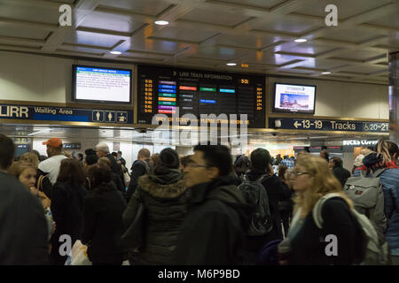 New York City, ca. 2017: Long Island Railroad Passagiere warten in der Lobby unter großen board Zeichen für Bahn Ansagen verlassen NYC Travel home Du Stockfoto