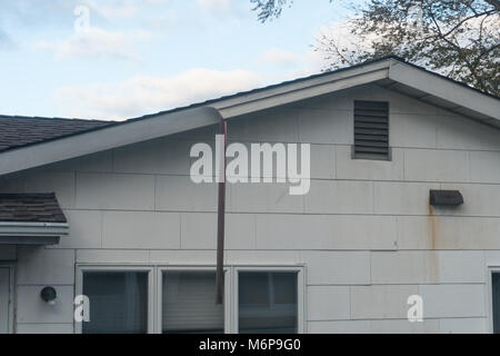 Hängende Stück von Dach- und Dichtungsbahnen fascia hängt von einem Haus, die durch starke Winde in einem Sturm beschädigt. Typische s-Ranch Haus außen während des Tages. Stockfoto