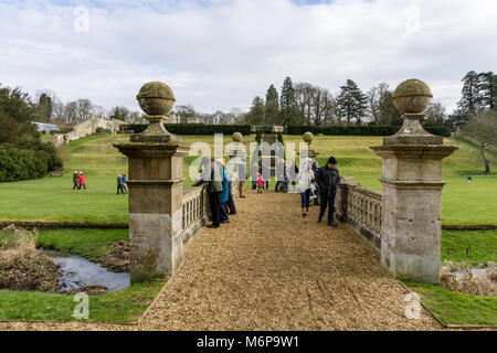 Easton ummauerten Gärten im Winter, mit Besucher bewundern die ornamentalen Brücke; in der Nähe von Grantham, Lincolnshire, Großbritannien Stockfoto