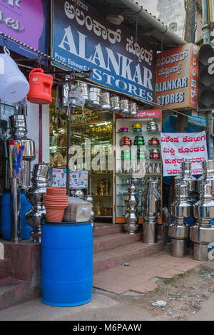Madikeri, Indien - 31. Oktober 2013: alankar Hardware Store zeigt Töpfe und Pfannen in glänzendem Metall und Farben. Reklametafeln und andere Haushalt und Küche Stockfoto
