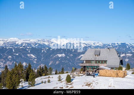 Blick auf die Hütte von schneebedeckten Gipfel des Berges Rennfeld und fernen Gipfeln der Berge Hochschwab im Winter Stockfoto