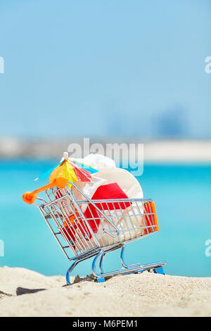 Miniatur Warenkorb mit plastik Müll durch touristische Links an einem tropischen Strand, Umweltverschmutzung Konzept Bild, selektive konzentrieren. Stockfoto