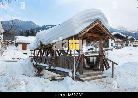 Schnee überdachte Holzbrücke im Winter in der Österreichischen Stadt Kleinarl. Stockfoto