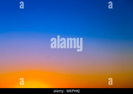Hintergrund mit Farbverlauf sonnenuntergang himmel in Tönen von gelb, orange und blau Stockfoto