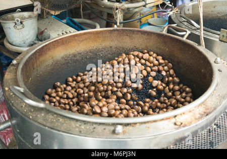 Die Röstung Kastanien auf großen Topf. Landwirtschaft Produkte von Gimyong Markt in Hatyai Thailand Stockfoto