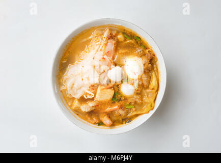 Blick von oben auf die würzigen TOM YAM Schweinefleisch nudeln Suppe auf weißem Hintergrund mit Freistellungspfad isoliert Stockfoto