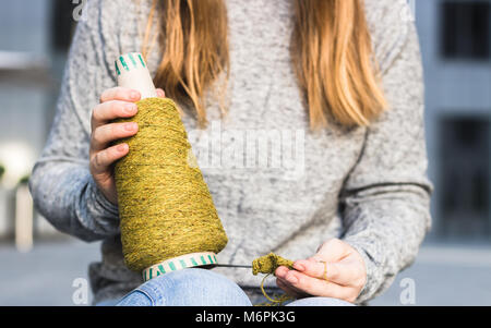 Thema Garn Stricken in der Hand einer Frau, die Nahaufnahme. Stricken, Hobby, Draußen, Frau, Geschäft, kreative Erfahrung, grün Thema Konzepte Stockfoto