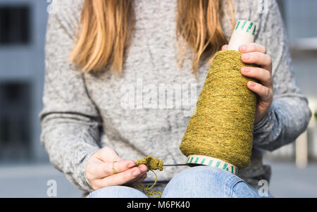 Thema Garn Stricken in der Hand einer Frau, die Nahaufnahme. Stricken, Hobby, Draußen, Frau, Geschäft, kreative Erfahrung, grün Thema Konzepte Stockfoto