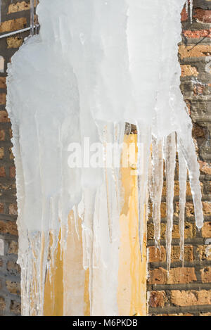 Eiszapfen an Mauer gebildet Stockfoto