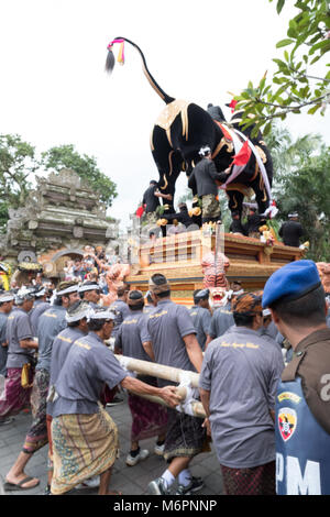 Balinesische Männer tragen die schwere schwarze Sarkophag Stier durch die Straßen von Ubud, Bali für die einäscherung Zeremonie der Königin Niang Agung Stockfoto